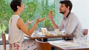 Una mesa de comedor con alimentos para el desayuno y una taza de café.