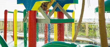 A water play area with colorful structures and a view of the ocean.