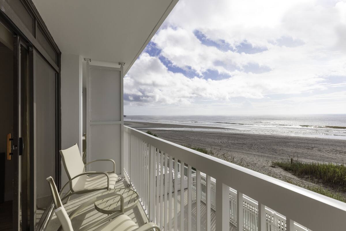 A balcony with a view of the beach.