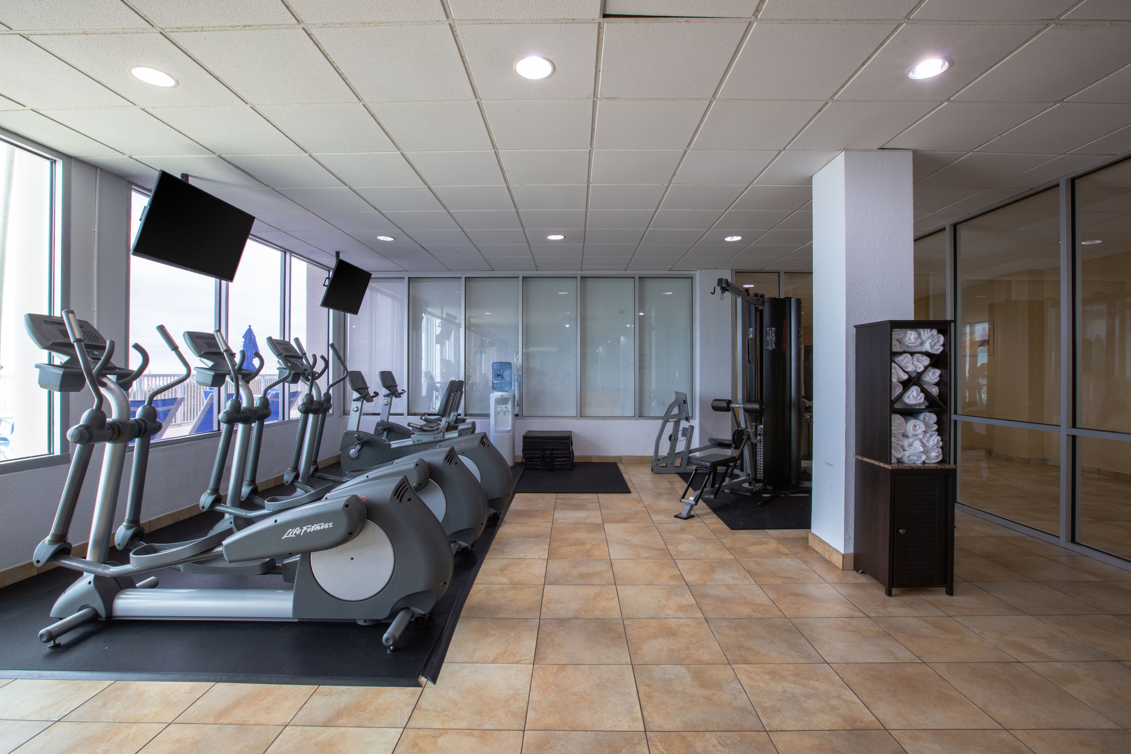 Una palestra con tapis roulant, cyclette e macchinari per l'allenamento con i pesi.