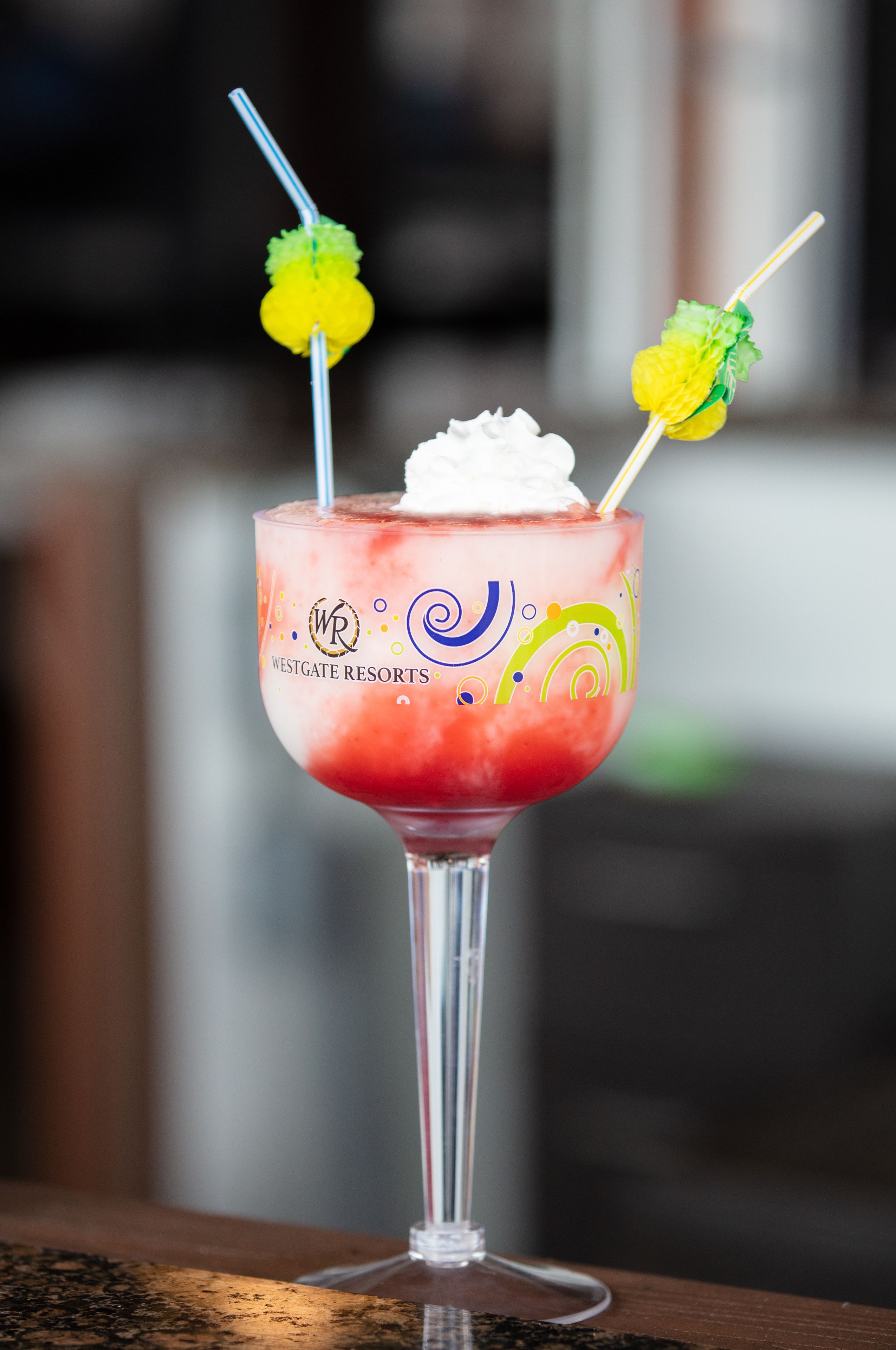 A cocktail in a glass with a straw and a decorative garnish.