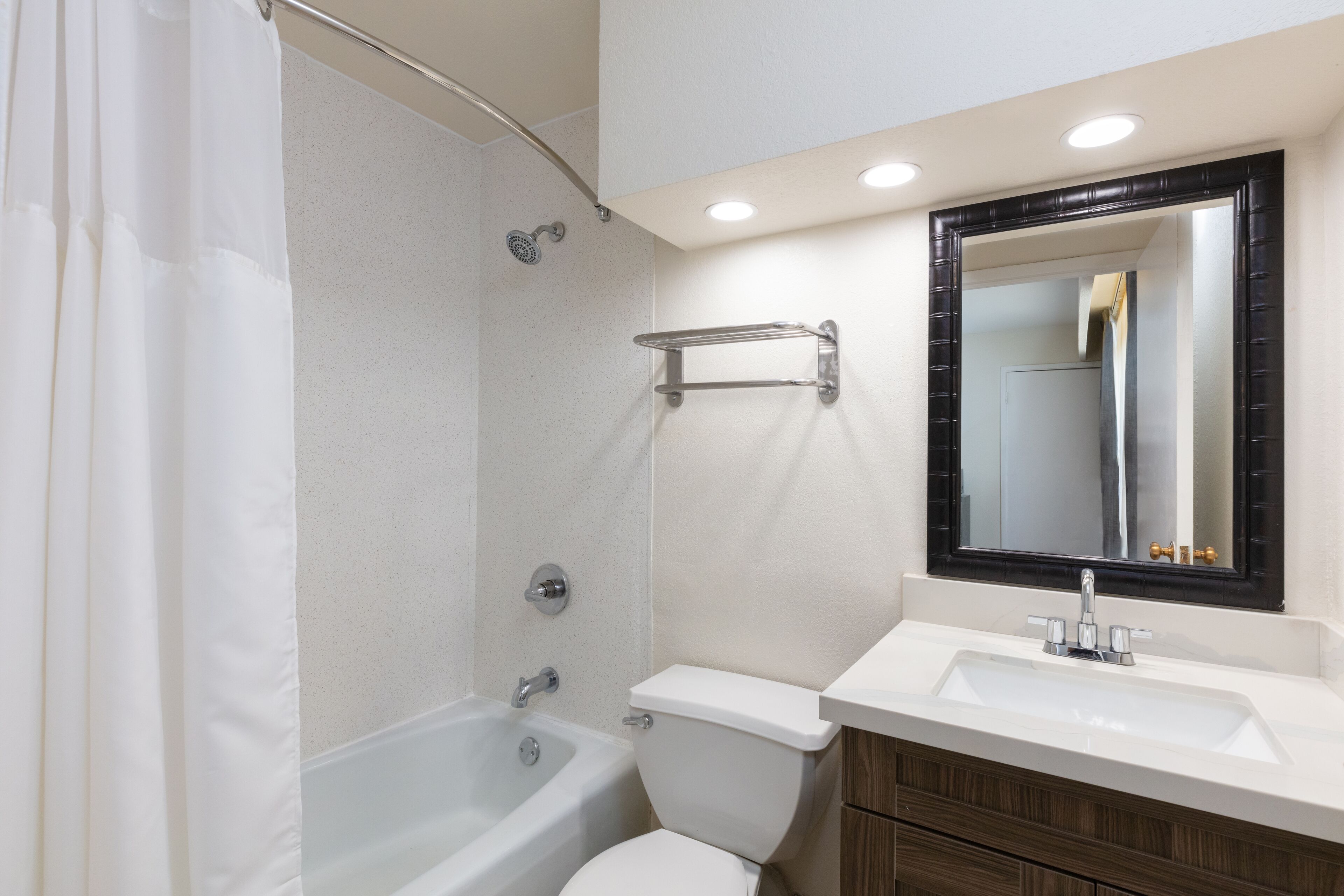 Un baño con bañera, inodoro y lavamanos.