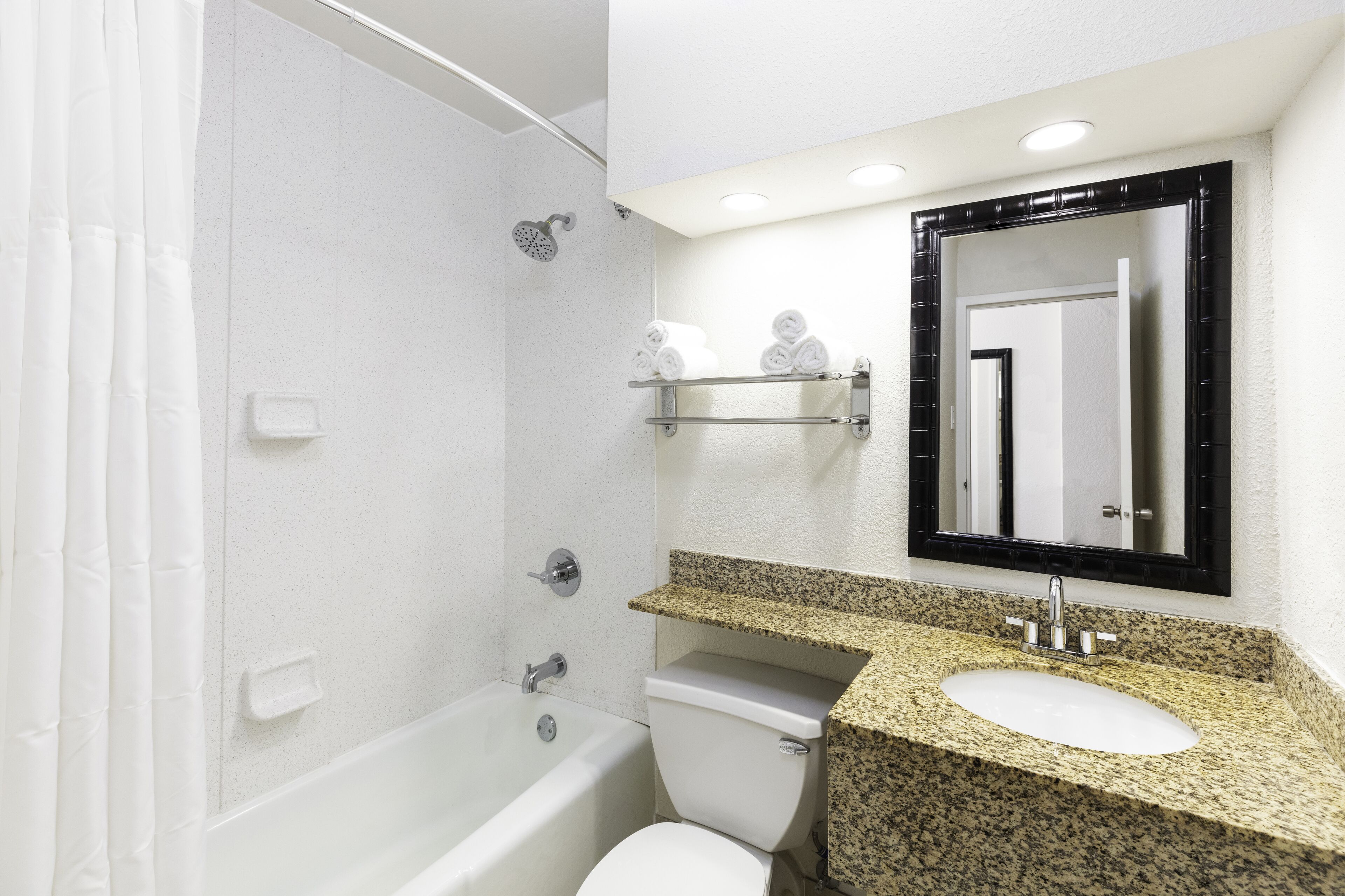 A bathroom with a bathtub, toilet, and sink.