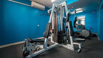 A gym with blue walls, a weight bench, and a treadmill.