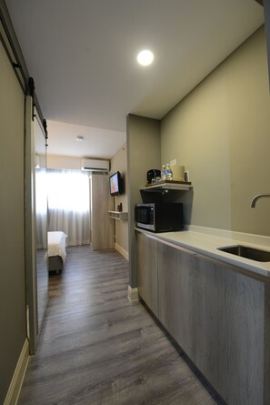 Cozy retreat with a kitchenette, television, and comfortable bed.