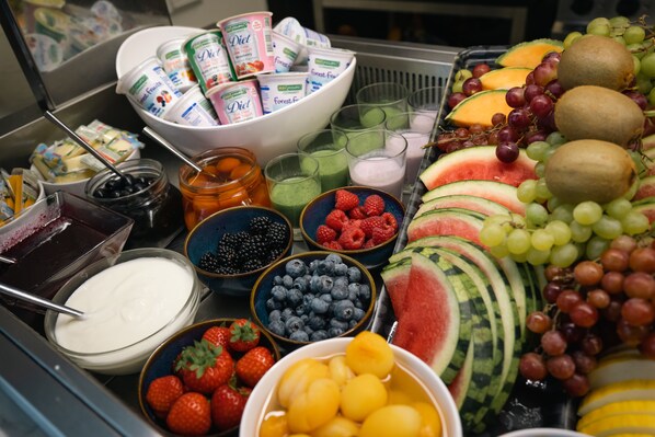 Une variété de fruits et de produits laitiers présentés dans un buffet.