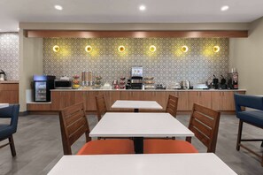 Un restaurante moderno con mostrador, zona de estar y diferentes electrodomésticos.
