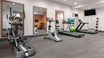 A gym with treadmills, an elliptical, and exercise balls.