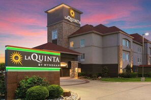 Un hôtel doté d’une enseigne bien visible indiquant « LA QUINTA BY WYNDHAM » et présentant un design architectural moderne.