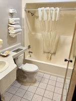 A bathroom with a toilet, sink, bathtub, and a towel rack.