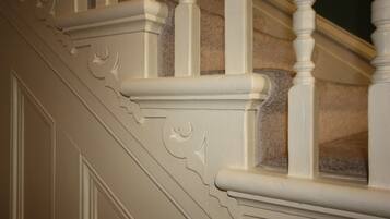 A close-up of a staircase with ornate white balusters and detailed molding.
