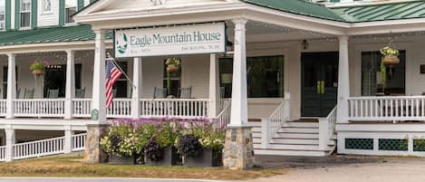 A two-story building with a porch and a sign reading 'Eagle Mountain House.'