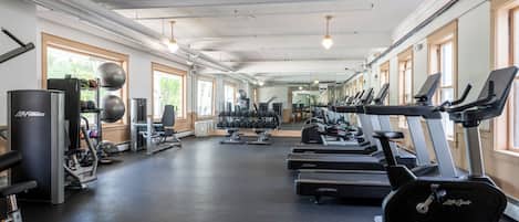 A gym with treadmills, dumbbells, and weight machines.