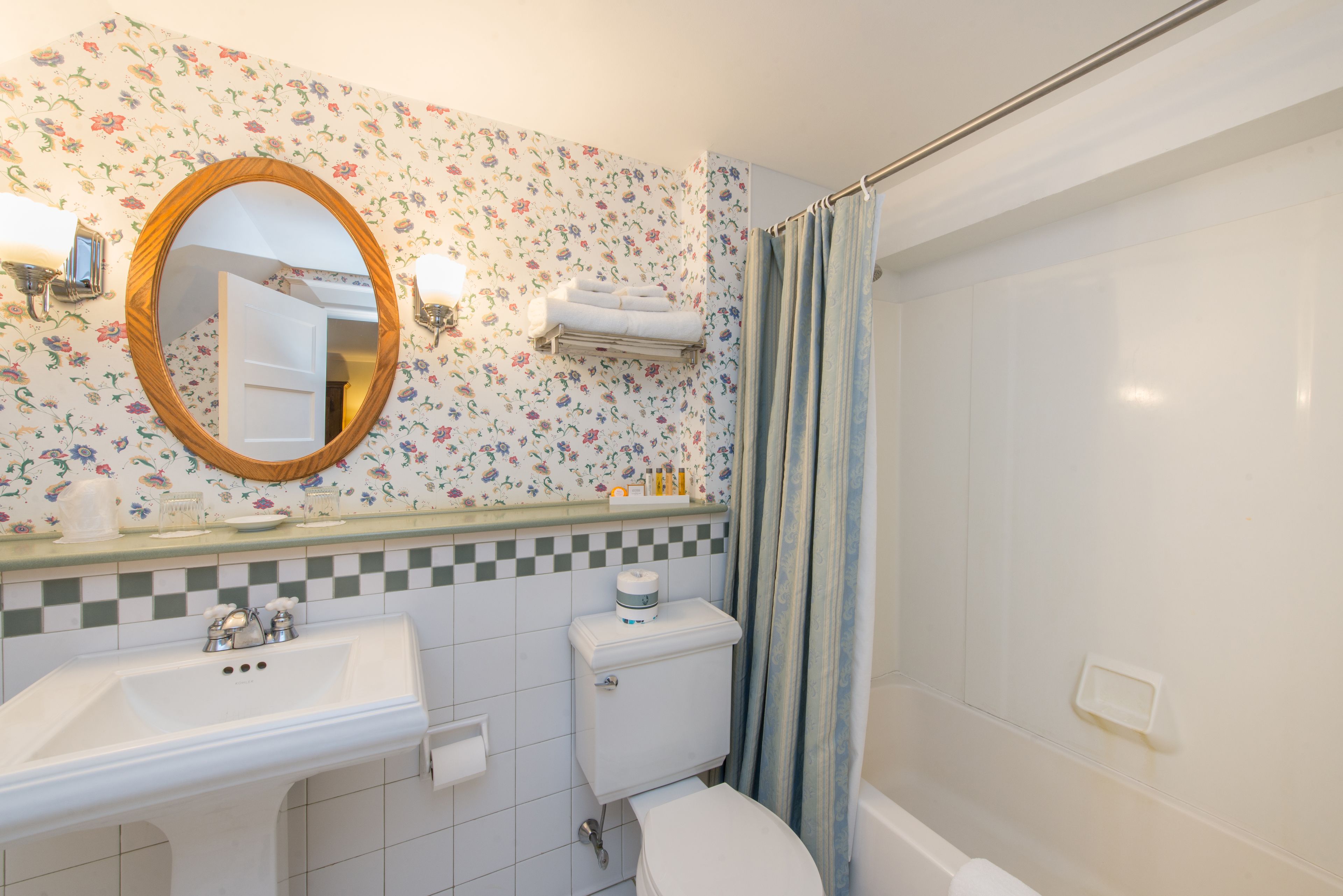 Un bagno con lavandino, WC, doccia e specchio.