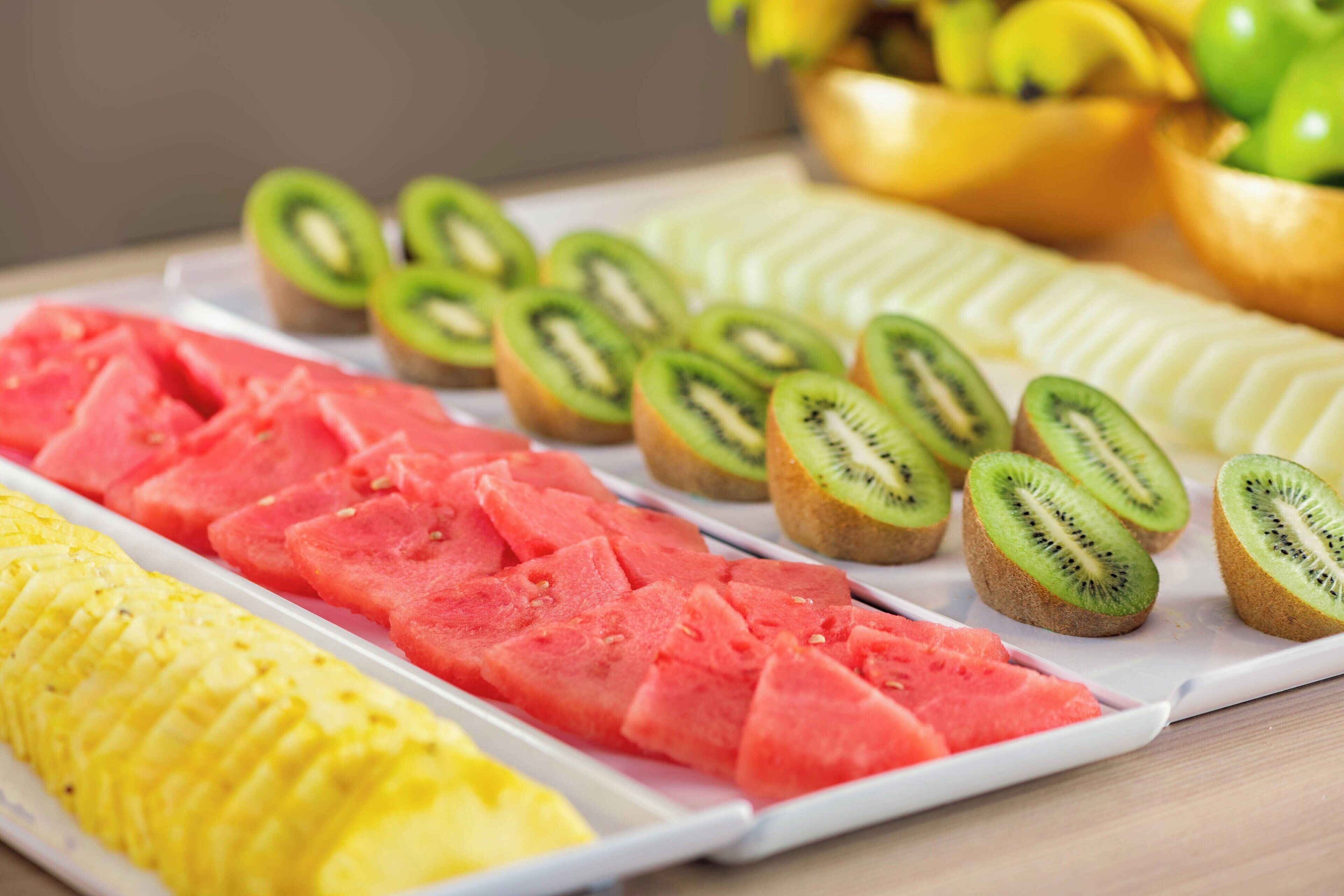 A tray of sliced fruits including watermelon, kiwi, and pineapple.