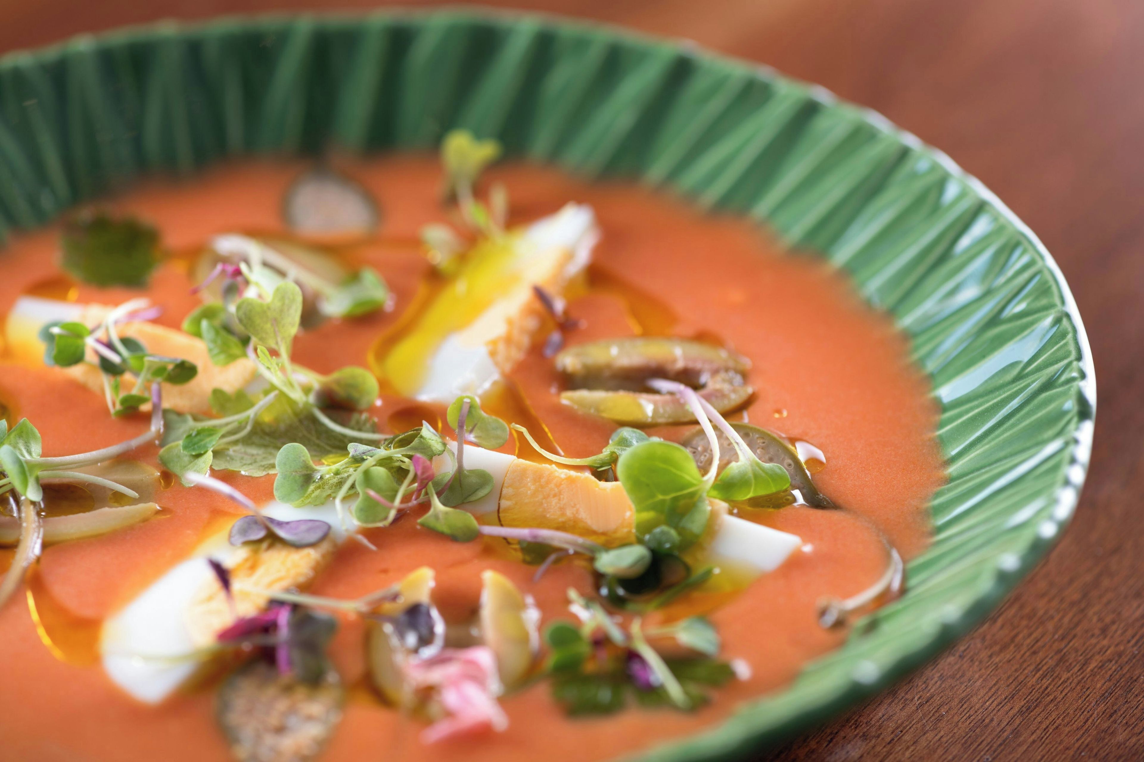 Un tazón de sopa con diferentes verduras y brotes.