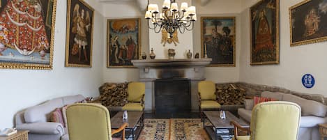 A traditional room with a fireplace, ornate paintings, and classic furniture.
