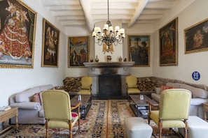A traditional room with a fireplace, ornate paintings, and classic furniture.