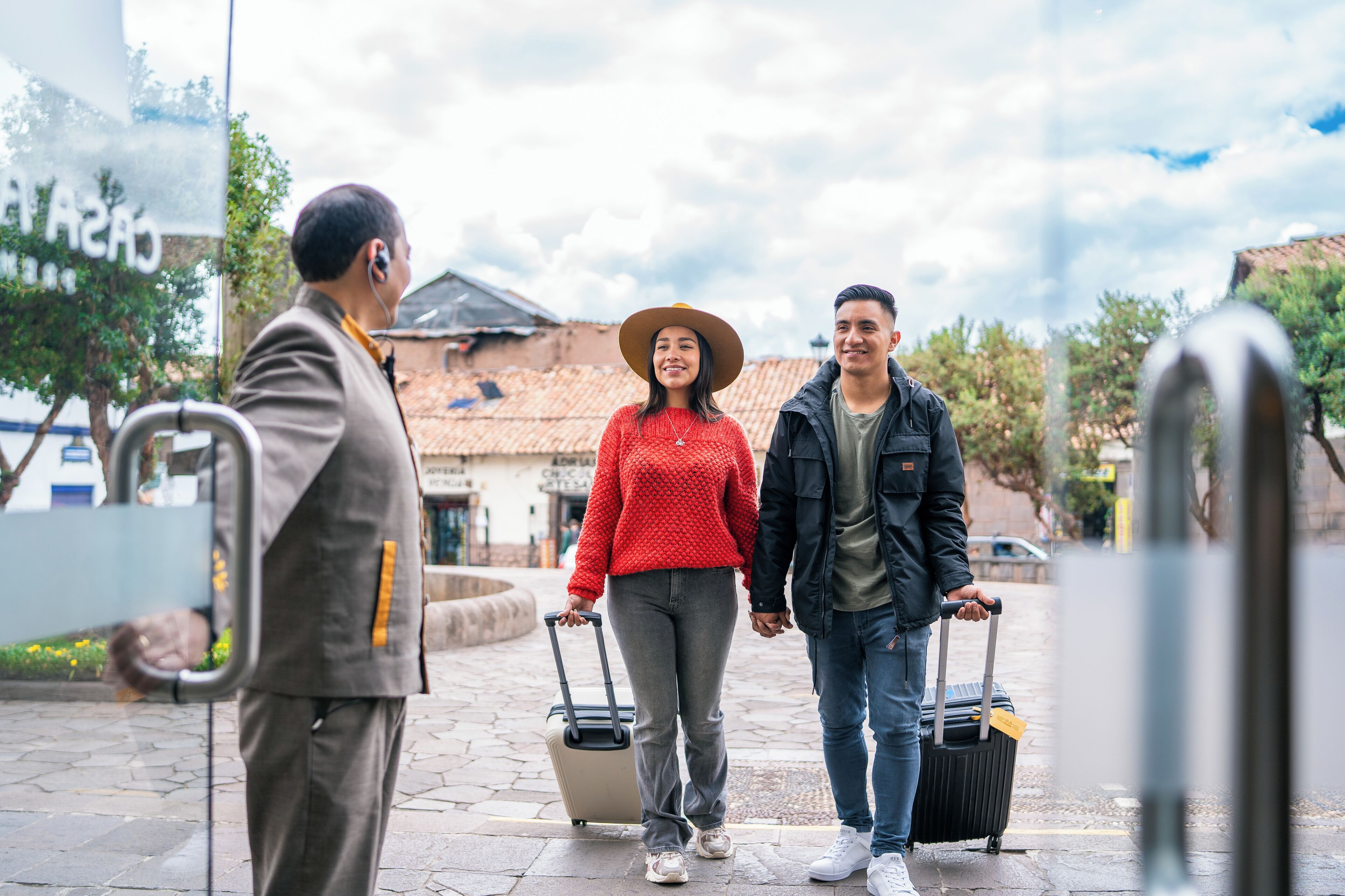 Three people walking on a paved area with a building in the background.