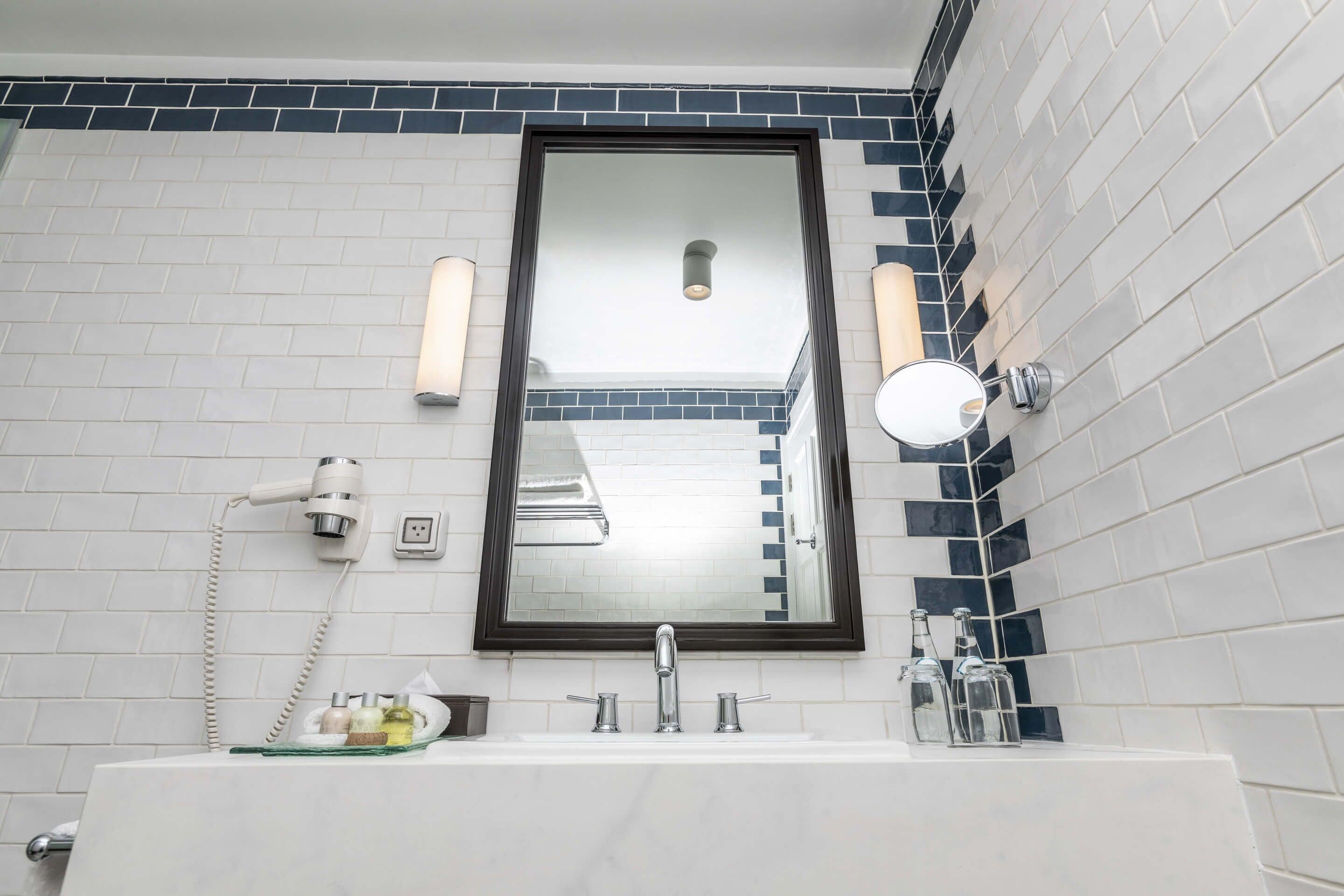 A bathroom with a white sink, a mirror, and two wall-mounted lights.