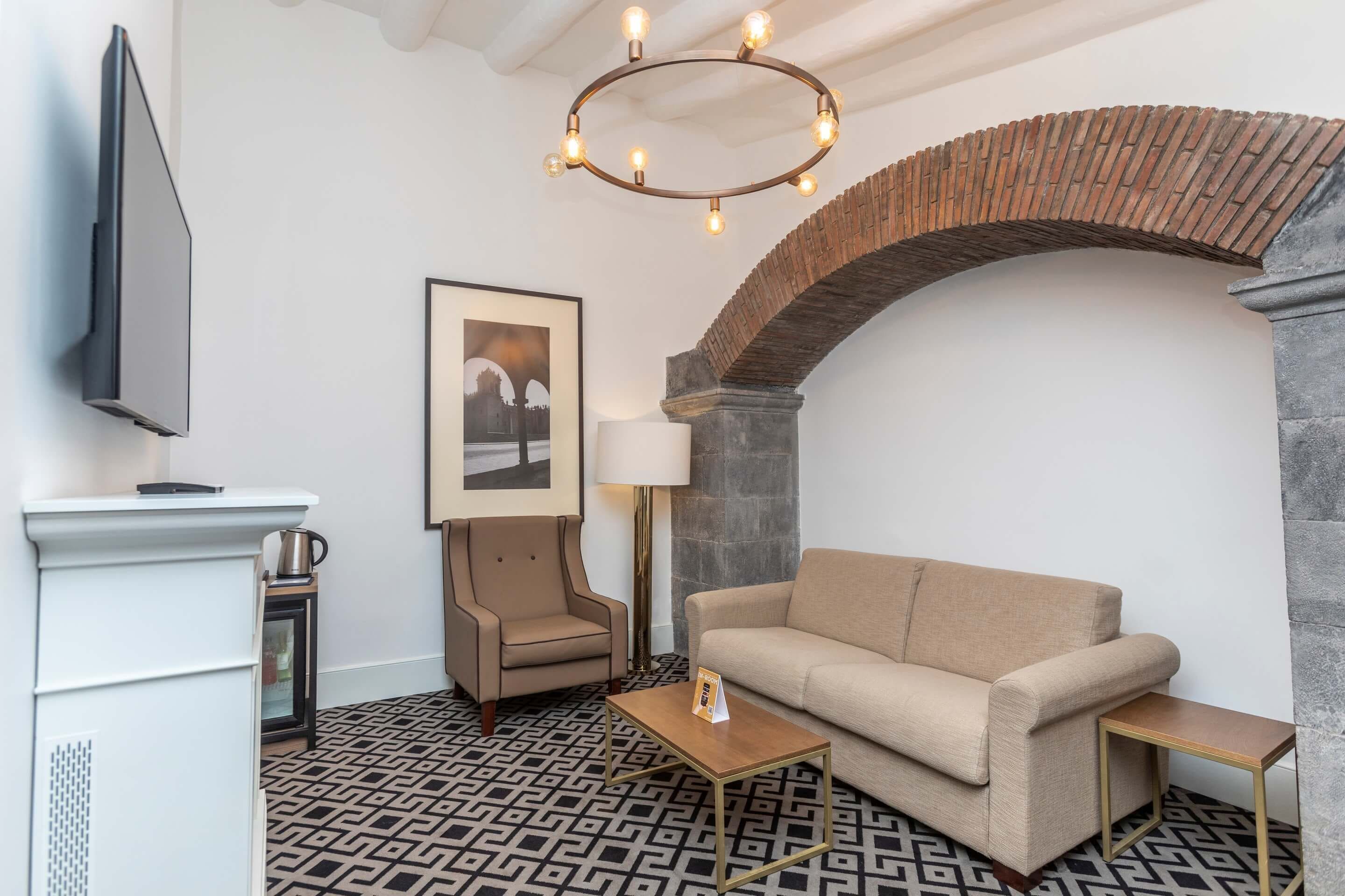 Uma sala de estar moderna com sofá, poltrona, mesa de centro e uma lareira.