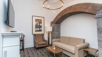 Uma sala de estar moderna com sofá, poltrona, mesa de centro e uma lareira.