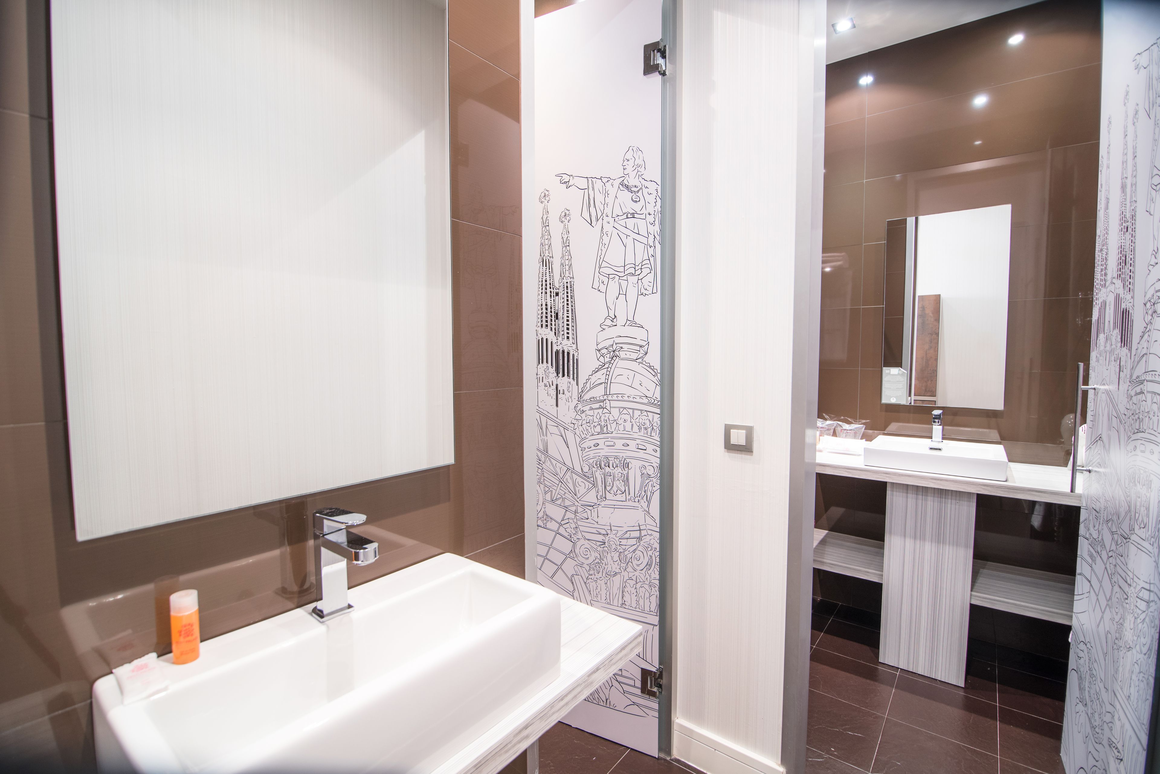 A modern bathroom with a large mirror, a white sink, and a shower area.