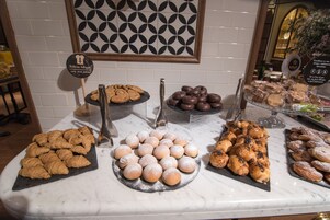 A bakery display with various pastries and cookies on marble countertops.