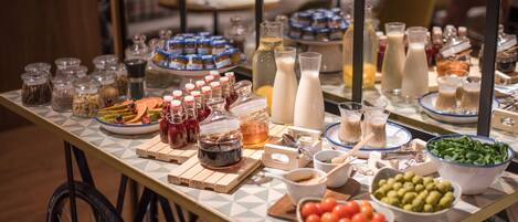 A buffet table with various food items and condiments.