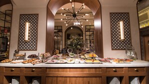 Un bufé con distintos alimentos y una lámpara decorativa en el techo.