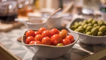 A table with a bowl of cherry tomatoes and a bowl of olives.