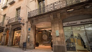 Un edificio con una tienda de bisutería llamada 'Anani Bisutería' y una zapatería llamada 'Roche'.
