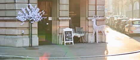 Hotel St. Georges with a classic facade, a signboard, and a decorative reindeer statue.
