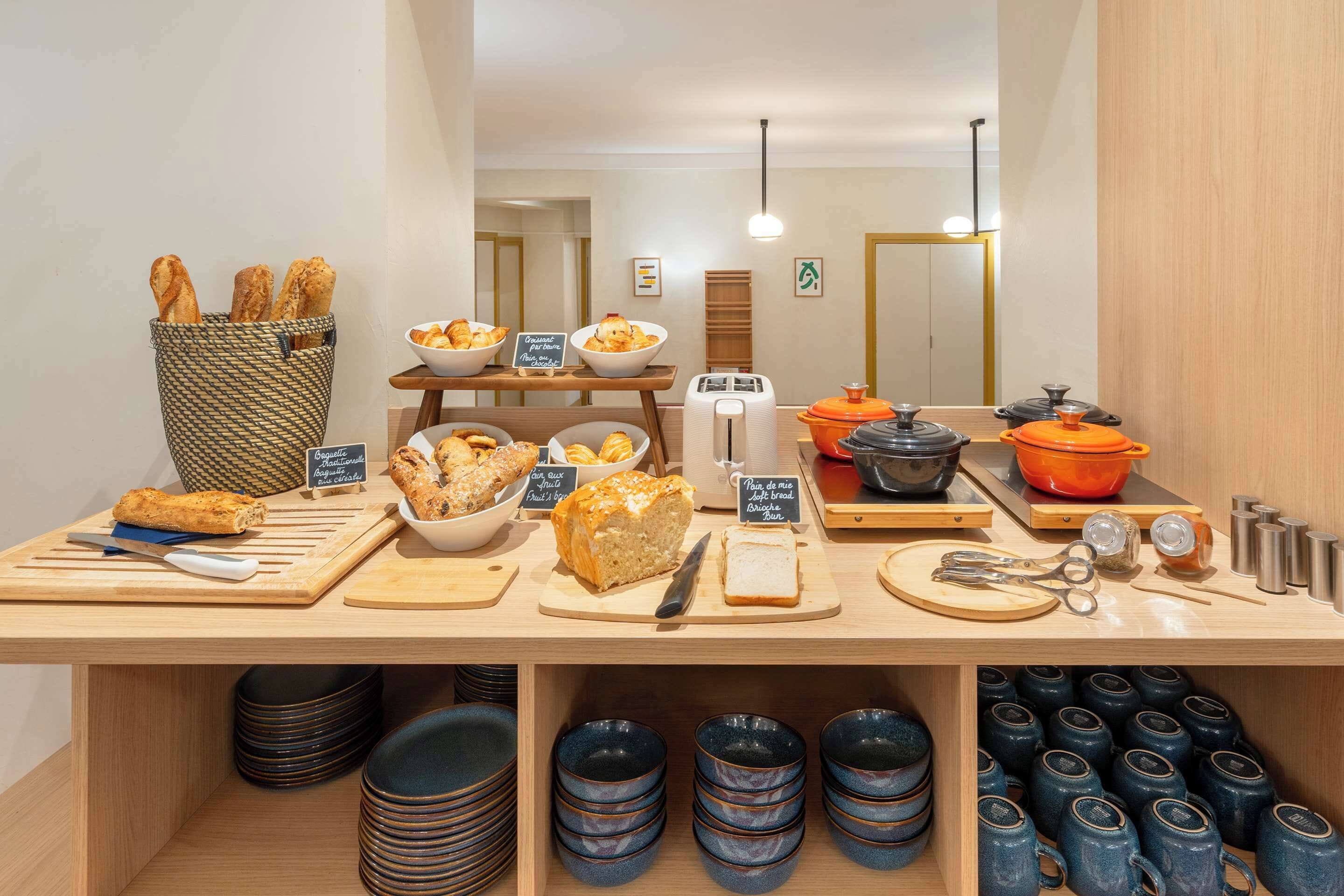 A breakfast buffet with bread, pastries, and a toaster.