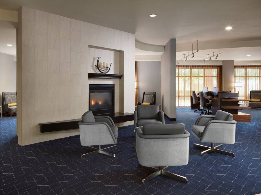 A modern lobby with a fireplace, comfortable seating, and large windows.