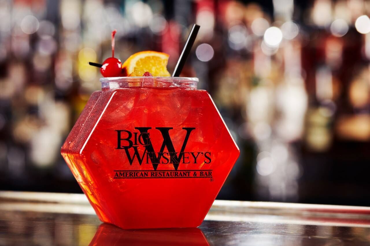 A hexagonal glass with a red drink, a cherry, and an orange slice, labeled "Big W's American Restaurant & Bar."