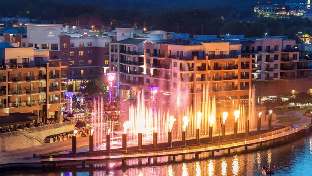 A hotel with a water fountain display and a view of the surrounding buildings.