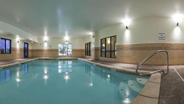 An indoor swimming pool with clear water, surrounded by walls with windows and a lifeguard sign. - Holiday Inn Express Hotel & Suites Rolla - U of Missouri S&T by IHG (Rolla)