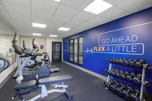A gym with exercise equipment, a wall with motivational text, and a rack of dumbbells. - Holiday Inn Express Hotel & Suites Rolla - U of Missouri S&T by IHG (Rolla)
