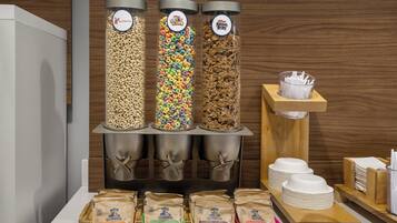 Una exhibición de alimentos con tres recipientes de cereal y paquetes de avena instantánea.