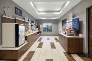 A modern breakfast area with a refrigerator, milk, eggs, and cereal display.