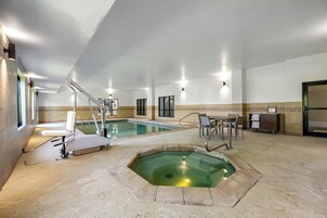 Un área de piscina con hidromasaje, asientos y vestuario.