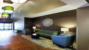 A lobby with a sofa, chairs, a patterned rug, and pendant lighting. - Holiday Inn Express & Suites Brandon by IHG (Brandon)