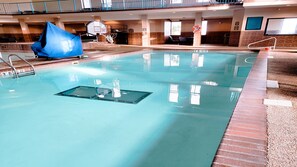 An indoor swimming pool with a diving board, a basketball hoop, and a lifebuoy. - Holiday Inn Express & Suites Brandon by IHG (Brandon)