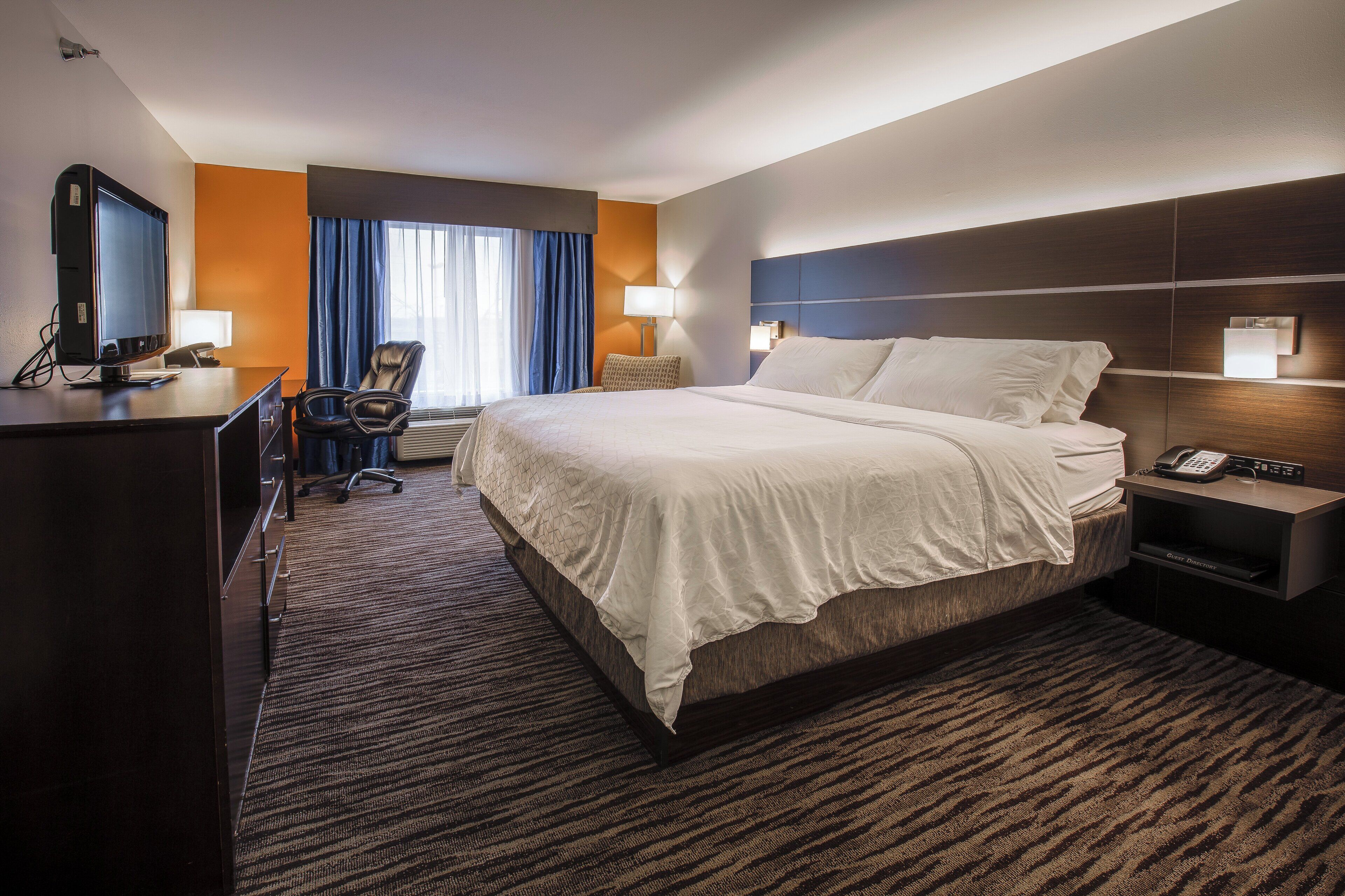 Ein Hotelzimmer mit Bett, Schreibtisch, Stuhl und Telefon.