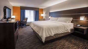 Ein Hotelzimmer mit Bett, Schreibtisch, Stuhl und Telefon.