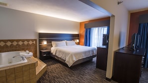 A hotel room with a large bed, a separate bathroom with a bathtub, a desk, and a television. - Holiday Inn Express & Suites Brandon by IHG (Brandon)