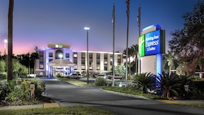 A Holiday Inn Express & Suites hotel with a well-lit entrance, a parking area, and a clear sky. - Holiday Inn Express Bartow by IHG (Bartow)