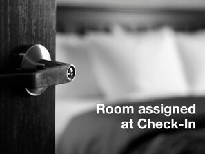 A hotel room door with a keyhole and a sign indicating room assignment at check-in.