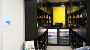 A corridor with shelves on both sides, a refrigerator at the end, and a sign on the left wall. - Holiday Inn Express Bartow by IHG (Bartow)